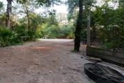 Rear view of sandy site 92 showing picnic table, fire ring and lantern post nestled under the shady live oak trees and maritime hammock in Anastasia State Park.