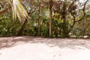 Frontal view of sandy site 106 showing electric and water hookups with live oak trees nestled under shady maritime hammock in  Anastasia State Park.