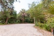 Frontal view of sandy site 130 showing picnic table with live oak trees nestled under shady maritime hammock in Anastasia State Park.