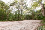 Side view of sandy site 131 showing picnic table with live oak trees nestled under shady maritime hammock in Anastasia State Park.