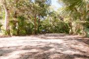 Frontal view of sandy site 134 showing picnic table with live oak trees nestled under shady maritime hammock in Anastasia State Park.
