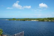 Photo: 004, View from cabin deck, overlooking boating basin with small spit of land, mangroves and open water in the background.