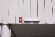 Photo: 004, Brown number plate with white number and the name Lagoon in white letters, on grey cabin.
