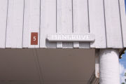 Photo: 005, Brown number plate with white number and the name Mangrove in white letters, on grey cabin.