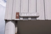 Photo: 006, Brown number plate with white number and the name Bayside in white letters, on grey cabin.