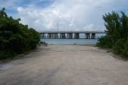Photo: Buttonwood: Gravel site with picnic table, bushes, water and new Bahia Honda Bridge in the background.
