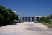 Photo: Buttonwood: Gravel site with picnic table, bushes on both sides, water and new Bahia Honda Bridge in the background.