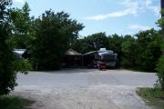 Photo: Buttonwood: Paved road with two occupied sites in background and bushes around sites
