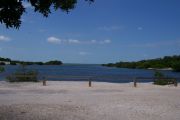 Photo: 073, BAYSIDE: Gravel road with wood fence, boating basin and bushes in the background.