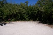 Photo: 077, BAYSIDE: Gravel road with wood fence, boating basin, bushes and cabins in the background.