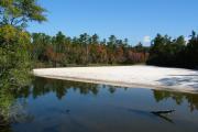 Brilliant, white sandy beach contrasting with tea colored water and blue skies overhead.