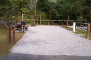 A view of the campsite with a shell/sand base and native vegetation.