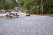 View of a picnic table and fire ring with clothes line.