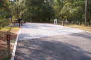 A view of the campsite with a shell/sand base and partial shade.