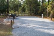 A view of the campsite with a shell/sand base and partial shade.