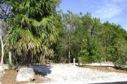 Photo: 011, JOHN PENNEKAMP CORAL REEF SP. Rock with campsite number, partially shaded gravel campsite with picnic table, grill, concrete sewer hookup basin, electric post, and paved road in foreground.