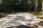 ADA-accessible campsite with concrete pad, picnic table and concrete sidewalk.