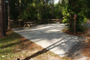 ADA-accessible pull-through campsite with concrete pad, picnic table and concrete sidewalk.
