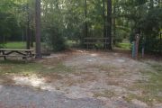 Campsite with picnic table and ground grill.