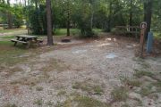 Campsite with picnic table and ground grill.