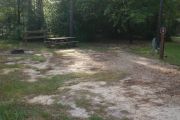 Campsite with picnic table and ground grill.