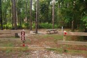 Campsite with picnic table and ground grill.