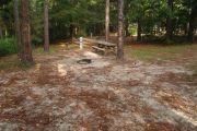 Campsite with picnic table and ground grill.