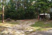 Campsite with picnic table and ground grill.
