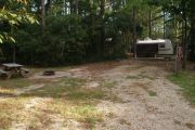 Campsite with picnic table and ground grill.