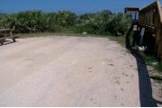 Beach overlook on the right side. Low palmetto plants and sea oats along the back. Electric and water on right.