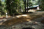 Campsite with ground grill with view of the restroom.