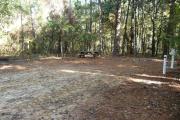 Campsite with picnic table and ground grill, electric and water hookups.