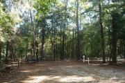 Campsite with picnic table and ground grill, electric and water hookups.