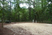 Campsite with picnic table and ground grill, electric and water hookups.