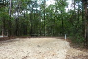 Campsite with picnic table and ground grill, electric and water hookups.