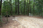 Campsite with picnic table and ground grill, electric and water hookups.