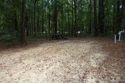 Campsite with picnic table and ground grill, electric and water hookups.