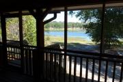 View from the porch of a modern ADA compliant cabin. This porch overlooks a beautiful blue lake.