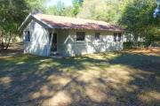 View of the front of a block cabin. The cabin is grey with white trim. These cabins are concrete block construction.