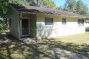 View of the front of a block cabin. The cabin is grey with white trim. These cabins are concrete block construction.