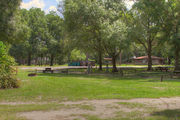 Sunny campsite with a picnic table and fire ring.