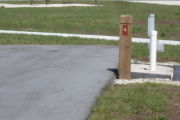 Photo: 009, Site number next to water and electric hook ups at the back of a gravel site.