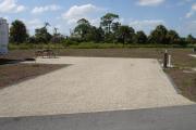 Campsite with picnic table, graill and rire ring on the left and water and electric on the right.