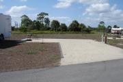 Campsite with picnic table, graill and rire ring on the left and water and electric on the right.