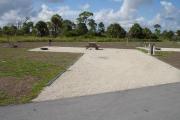 Campsite with picnic table, grill and fire ring on the left and water and electric on the right.
