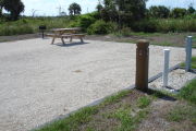 Photo: 014, Site number next to water and electric hooks ups at the back of a gravel site.