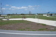 Photo: 016, Campsite with picnic table, grill and fire ring on the left and water and electric on the left.