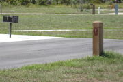 Photo: 021, Site number next to water and electric hooks ups at the back of a gravel site.