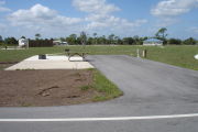 Photo: 021, ADA-accessible campsite with picnic table, grill and fire ring on the left and water and electric on the left.