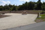 Photo: 022, Campsite with picnic table, grill and fire ring on the left and water and electric on the left.